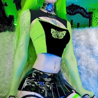 a woman with green hair is posing on a couch