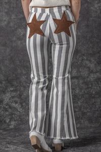 the back view of a woman wearing striped pants with stars